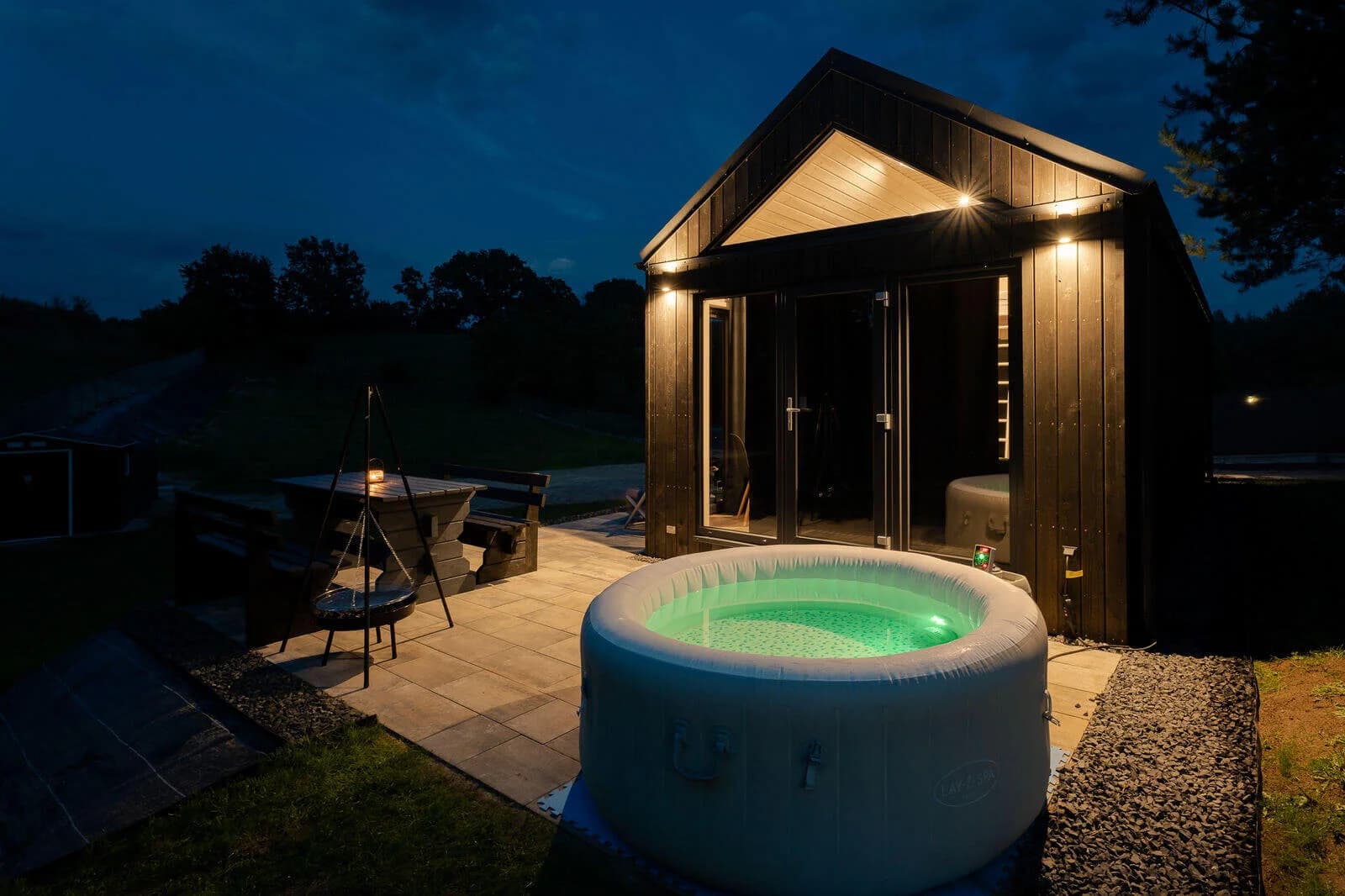 Podświetlone jacuzzi na tarasie domku Premium wieczorem